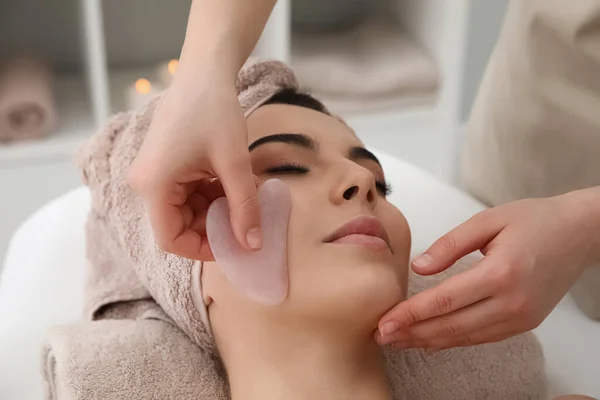 Jovem Mulher Recebendo Massagem Facial Com Ferramenta Gua Sha Salão — Fotografia de Stock