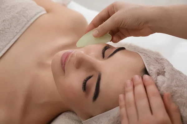 Mujer Joven Recibiendo Masaje Facial Con Herramienta Gua Sha Salón — Foto de Stock