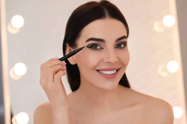 Piękna Młoda Kobieta Stosując Czarny Eyeliner Wewnątrz — Zdjęcie stockowe