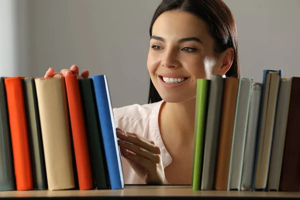 Woman searching for book on shelf in library