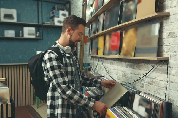 Delikanlı mağazada plak seçiyor.