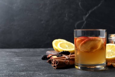 Kurutulmuş elma dilimleri ve siyah masa üzerindeki malzemelerle nefis bir komposto, metin için yer.