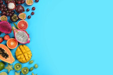 Açık mavi arka planda pek çok farklı lezzetli egzotik meyve, düz uzanıyordu. Metin için boşluk