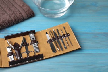 Manicure set in case on light blue wooden background clipart