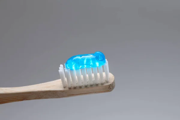 Szczoteczka Drewniana Pastą Zębów Szarym Tle Zbliżenie — Zdjęcie stockowe
