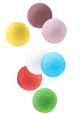 Beyaz arka plana düşen birçok farklı aromatik banyo bombaları.