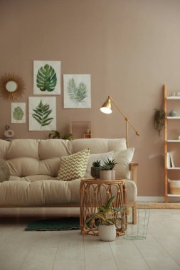 Şık bir iç mekan, rahat bir kanepe ve duvarda güzel resimler.