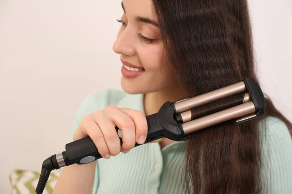 Mujer Joven Usando Rizador Moderno Sobre Fondo Claro Primer Plano —  Fotos de Stock