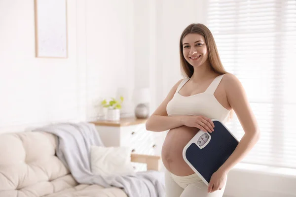 自宅で体重計を持つ若い妊婦 テキストのスペース — ストック写真