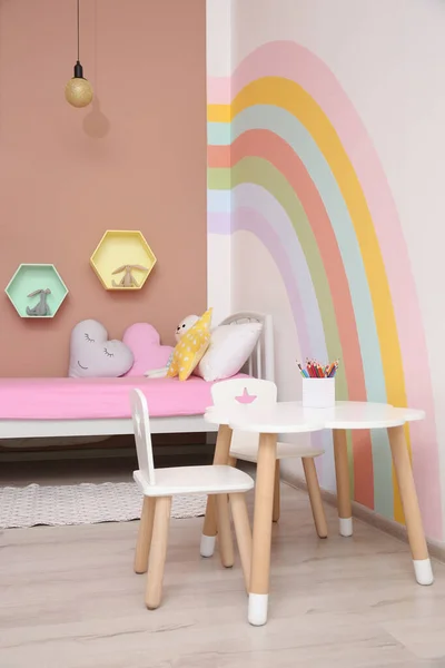 壁に美しい虹が描かれたかわいい子供部屋のインテリア — ストック写真