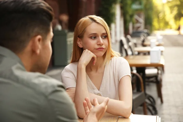在户外咖啡馆和男人初次约会时 年轻女人感到厌烦 — 图库照片