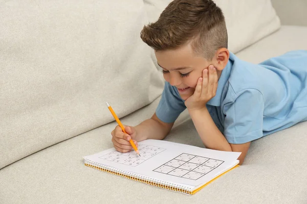 Kleiner Junge Löst Sudoku Rätsel Hause Auf Dem Sofa — Stockfoto