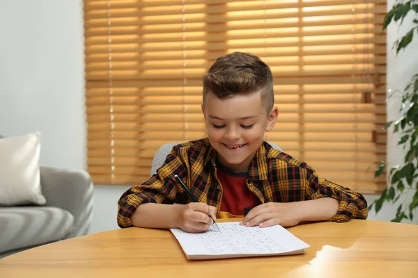 Liten Pojke Lösa Sudoku Pussel Vid Bordet Inomhus — Stockfoto