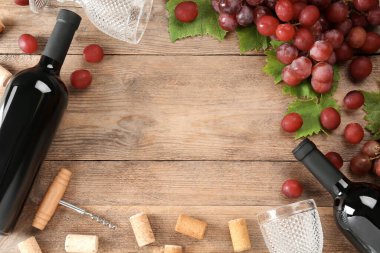 Lezzetli kırmızı şarap ve üzümlerle ahşap masa üzerinde düz kompozisyon, metin için boşluk