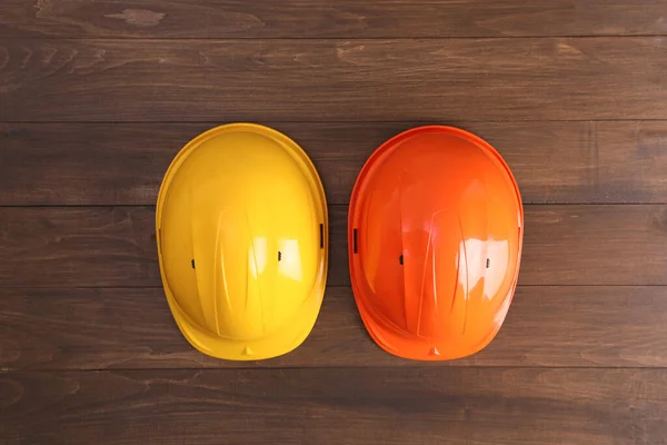 Different Hard Hats Wooden Table Flat Lay — Stockfoto