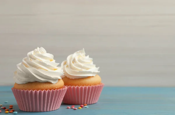 Heerlijke Cupcakes Versierd Met Room Lichtblauwe Houten Tafel Ruimte Voor — Stockfoto