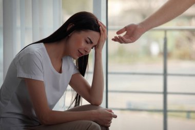 Depresyondaki kadına el uzatan bir adam.