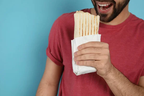 Ung Man Äter Välsmakande Shawarma Turkos Bakgrund Närbild — Stockfoto