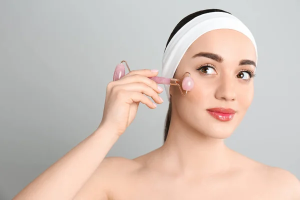 Mujer Usando Rodillo Cuarzo Rosa Natural Sobre Fondo Gris —  Fotos de Stock