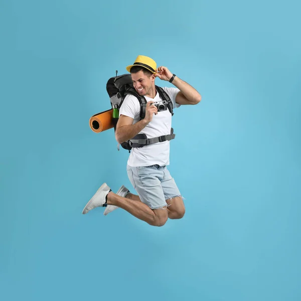 Mannelijke Toerist Met Reisrugzak Camera Springen Turquoise Achtergrond — Stockfoto