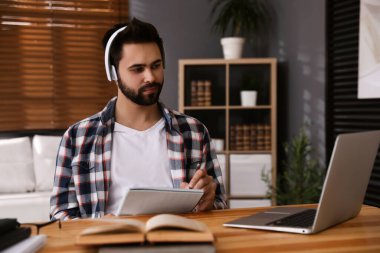 Genç adam masadaki Webinar 'ı izliyor.