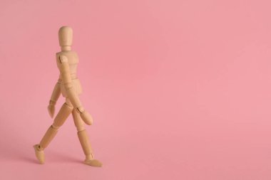 Pembe arka planda ahşap insan modeli, mesaj için boşluk. Mini manken.