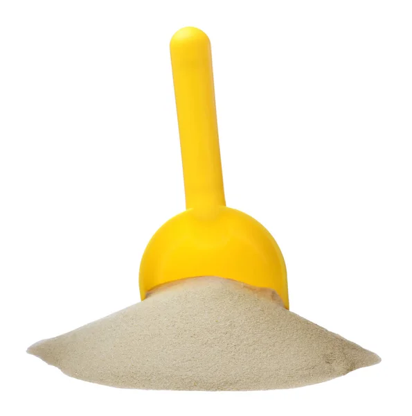 白い背景に砂と黄色のプラスチック製のおもちゃのシャベルの山 — ストック写真