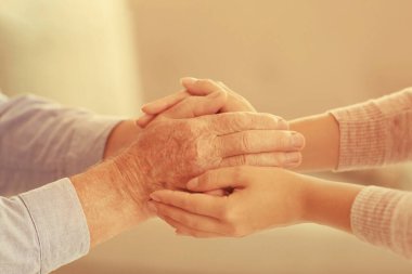 Bulanık arka planda ellere yardım etmek, yakın çekim. Yaşlılara bakım kavramı