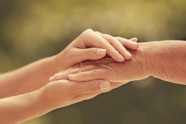 Bulanık arka planda ellere yardım etmek, yakın çekim. Yaşlılara bakım kavramı