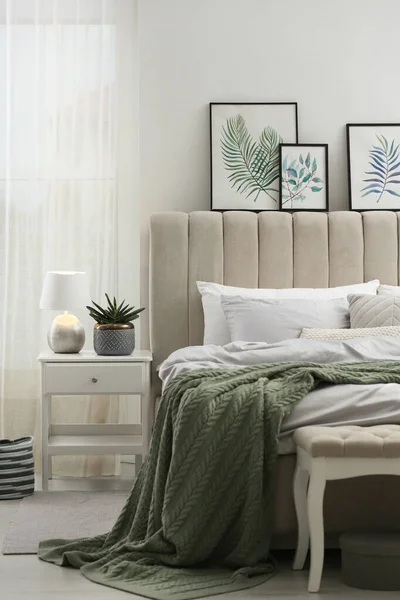 部屋の白い壁の近くにスタイリッシュな灰色のリネンのベッド — ストック写真