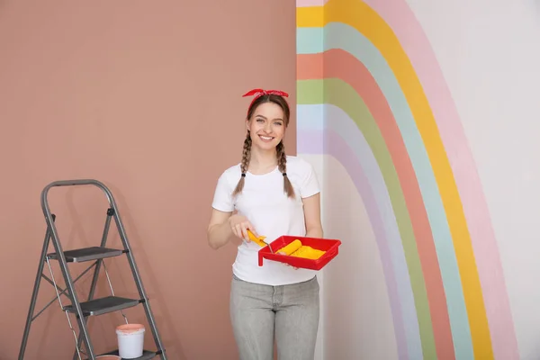 Young Woman Holding Tray Roller Wall Painted Rainbow Indoors — Stock Photo, Image