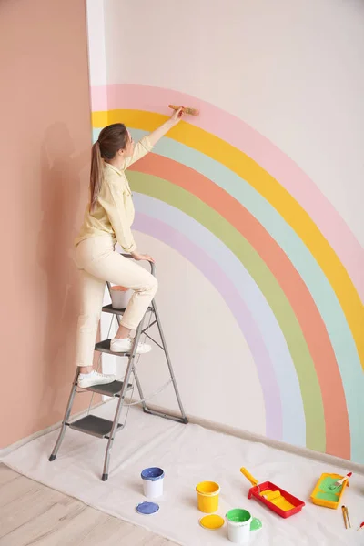 Молода Жінка Малює Веселку Білій Стіні Приміщенні — стокове фото