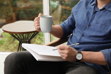 Evdeki sudoku bulmacasını çözen adam, yakın plan