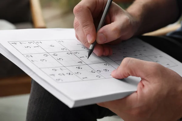 Hombre Resolviendo Rompecabezas Sudoku Interiores Vista Cerca — Foto de Stock