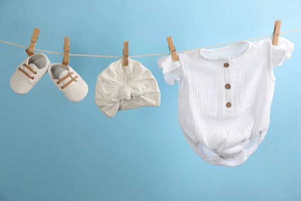 Babybekleidung Und Accessoires Hängen Der Wäscheleine Vor Hellblauem Hintergrund — Stockfoto
