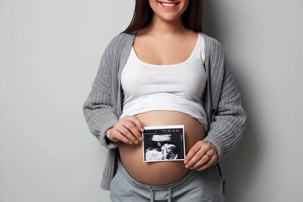 Giovane Donna Incinta Con Ecografia Del Bambino Sfondo Grigio Primo — Foto Stock