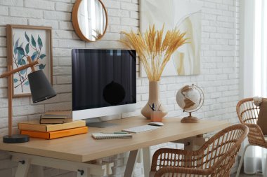 Beyaz tuğla duvarın yanında rahat işyeri olan şık bir ofis.