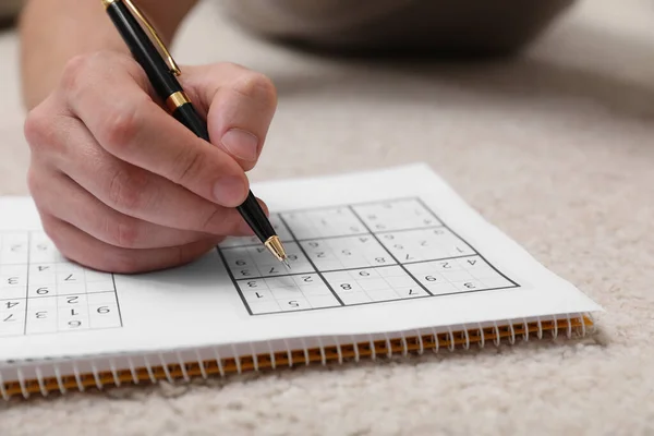 Homme Résoudre Puzzle Sudoku Sur Sol Maison Gros Plan — Photo