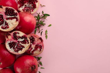 Pembe arka planda olgun nar içeren düz bir kompozisyon. Metin için boşluk