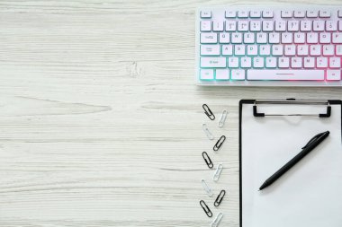 Beyaz ahşap masa üzerinde modern RGB klavyesi ile düz kompozisyon, metin için boşluk