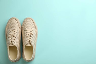 Turkuaz arka planda bir çift şık rahat ayakkabı, düz yatış. Metin için boşluk
