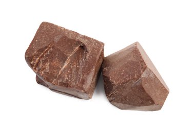 Beyaz arka planda lezzetli sütlü çikolata parçaları, üst manzara.