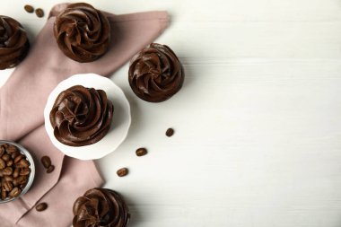 Düz kompozisyon ve beyaz ahşap masanın üzerinde çikolatalı kekler. Metin için boşluk