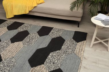 Odanın ahşap zemininde geometrik desenli halı.