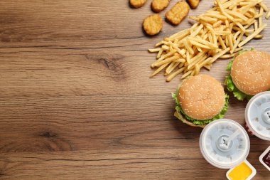Düz kompozisyon ve ahşap masada lezzetli fast food menüsü. Metin için boşluk