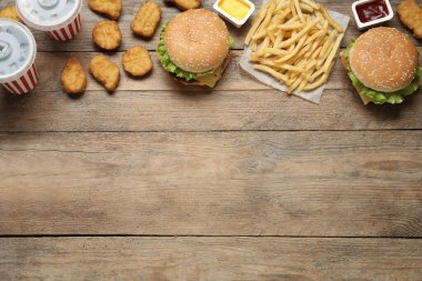 Düz kompozisyon ve ahşap masada lezzetli fast food menüsü. Metin için boşluk