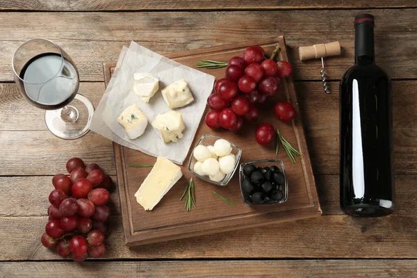 平铺着红葡萄酒和小吃在木制桌子上的构图 — 图库照片