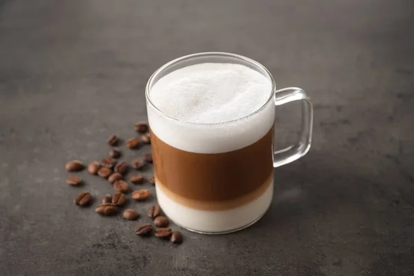 Warme Koffie Met Melk Glazen Beker Bonen Grijze Tafel — Stockfoto