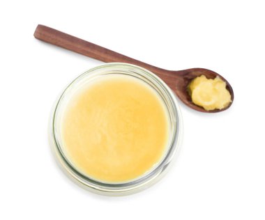Cam kavanoz ve kaşık dolusu Ghee yağı beyaza izole edilmiş.