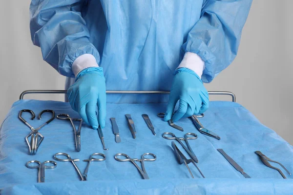 Médico Tomando Instrumentos Quirúrgicos Mesa Sobre Fondo Claro Primer Plano —  Fotos de Stock